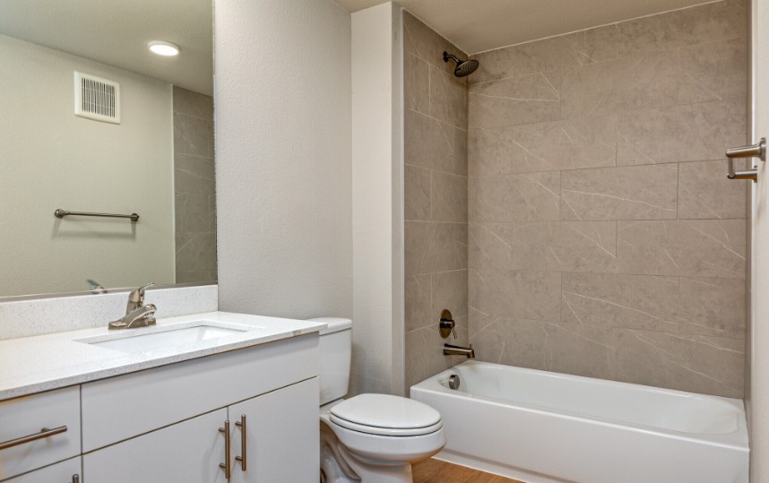 A white bathroom with a toilet, sink, and bathtub.